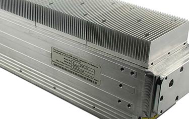 Un dissipateur thermique rectangulaire métallique avec des ailettes verticales rapprochées, conçu pour compléter la précision industrielle de lEpilog Fusion Maker 12. Il présente une surface nervurée et un panneau latéral étiqueté avec un code-barres et des spécifications techniques, conservant une esthétique utilitaire.