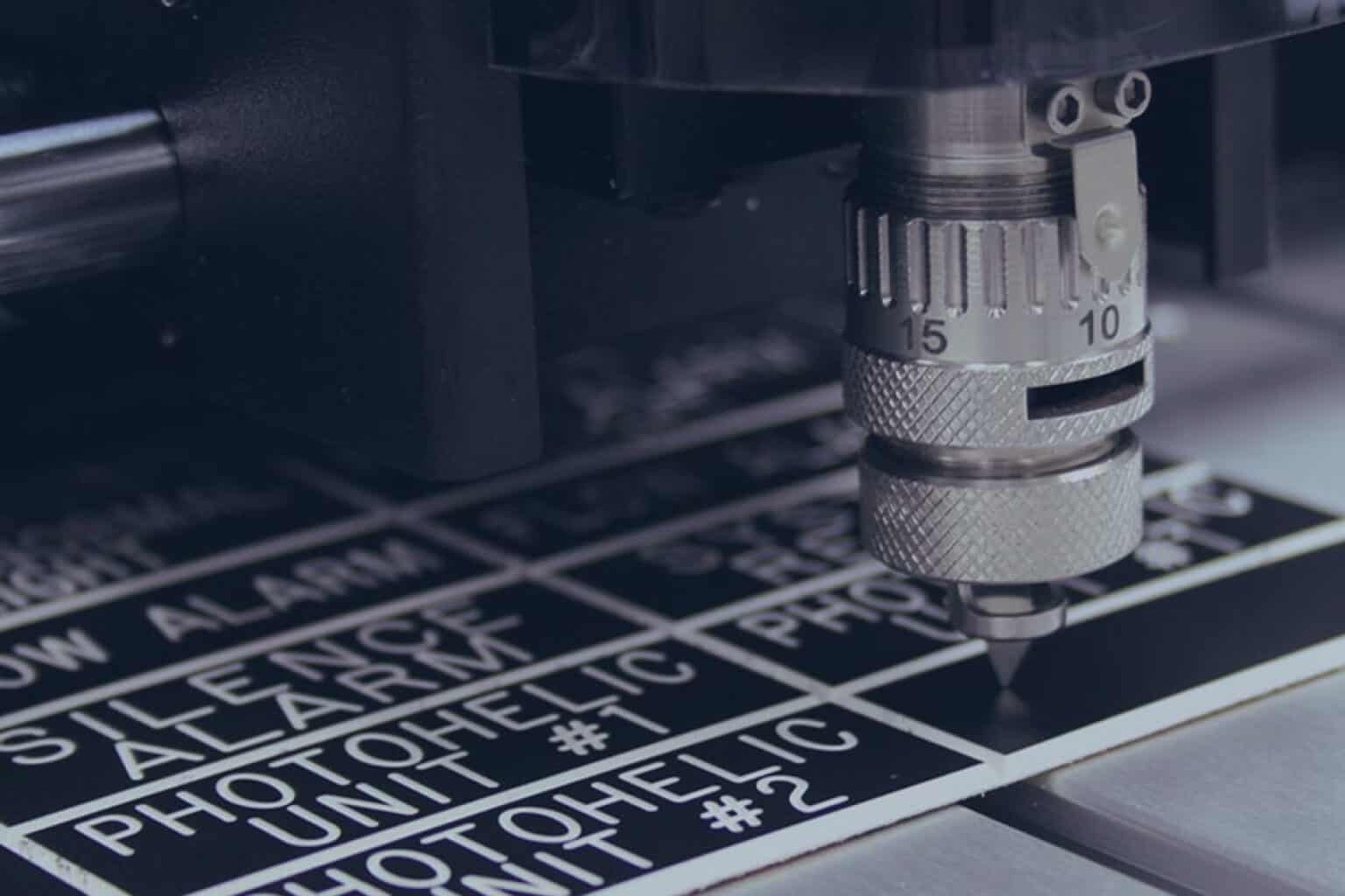Une fraiseuse grave une plaque de matière