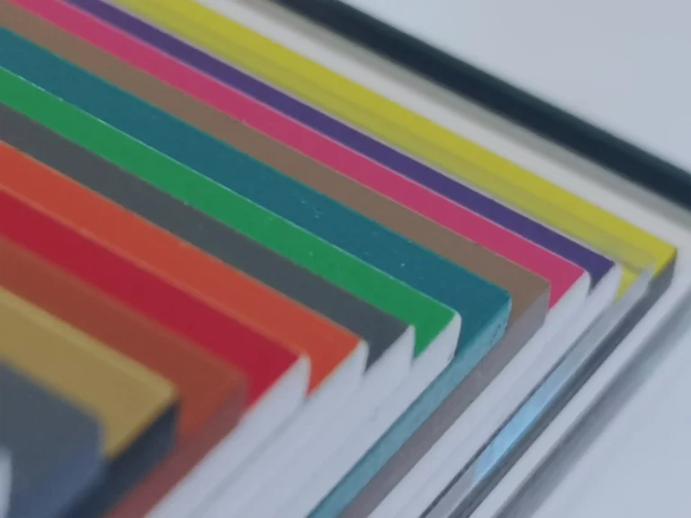 Gros plan de livres empilés colorés aux bords visibles. Les couvertures sont de différentes couleurs, dont le rouge, le vert, le bleu, le violet et le jaune. La photo met laccent sur les teintes vives et la disposition en couches.