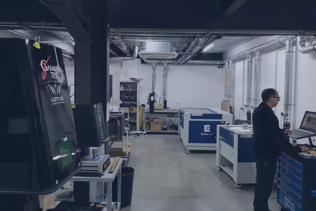 Locaux de GAMMA-TEC, on y voit un technicien sur un ordinateur en train de préparer des machines laser