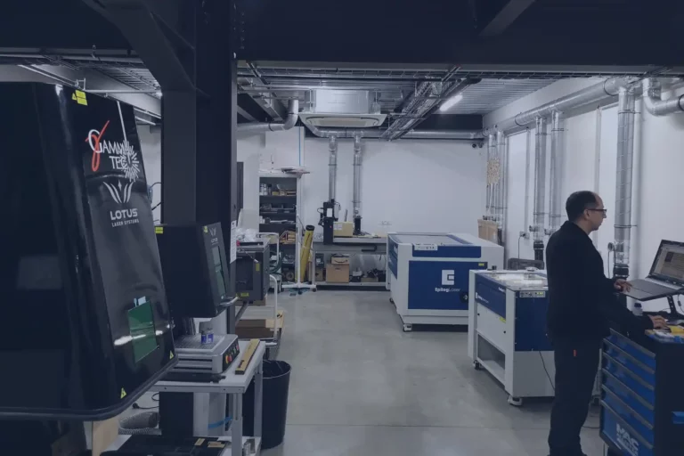 Locaux de GAMMA-TEC, on y voit un technicien sur un ordinateur en train de préparer des machines laser