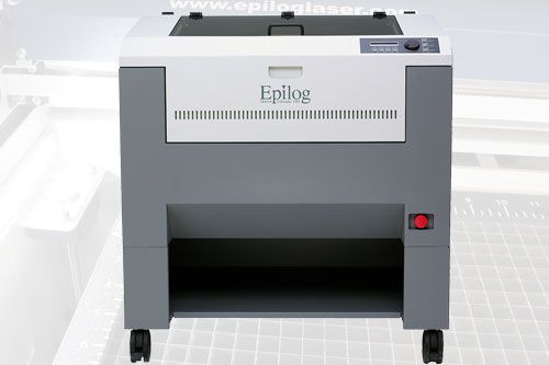 A propos de précision et de mobilité, cette machine de gravure laser Epilog sur roulettes présente un design blanc et gris élégant avec des boutons de commande intuitifs sur le dessus. En arrière-plan, le contour flou dune surface découpée au laser laisse entrevoir des possibilités créatives infinies.