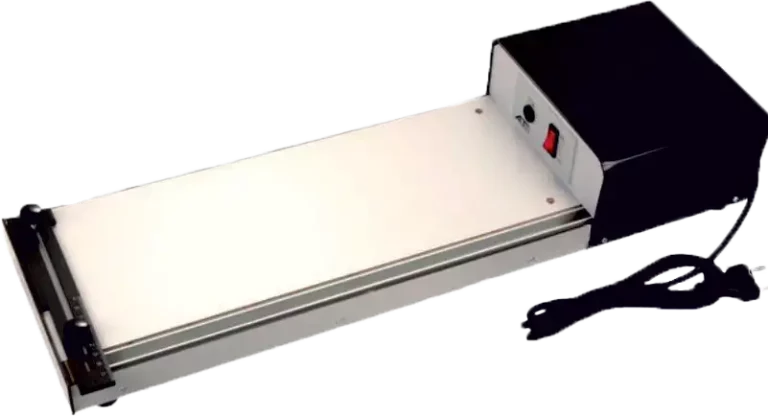 Une machine à plier le papier électrique noire et argentée, ressemblant à une biseauteuse, avec une longue surface plane, un guide de mesure sur un côté et un interrupteur dalimentation sur le boîtier de commande noir à lextrémité, ainsi quun cordon dalimentation.