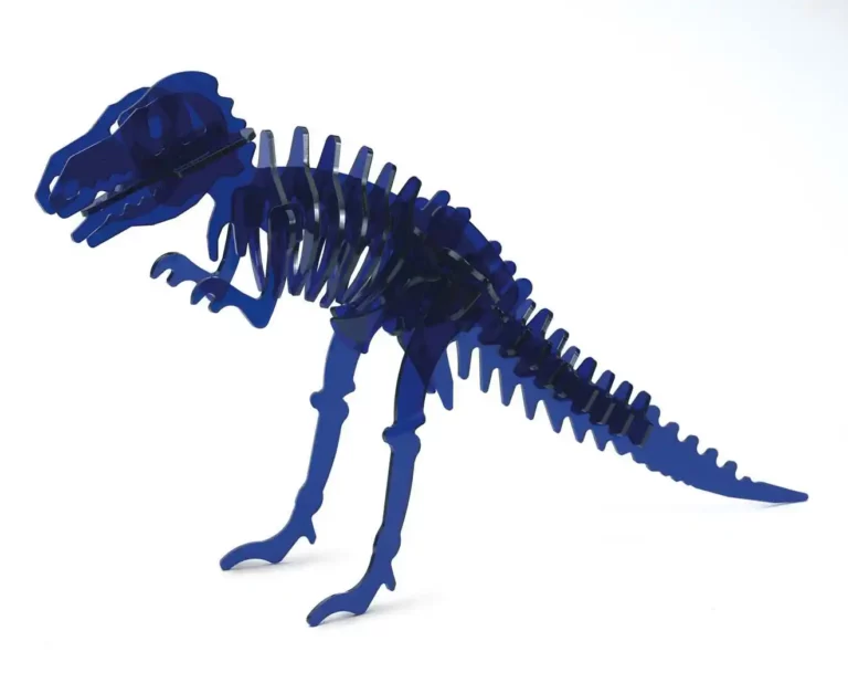 Un puzzle de dinosaure bleu en 3D, rappelant un squelette de T-Rex, est assemblé de manière experte à partir de pièces en acrylique. Ses composants incurvés façonnent le corps, les pattes et la queue sur un fond blanc simple.