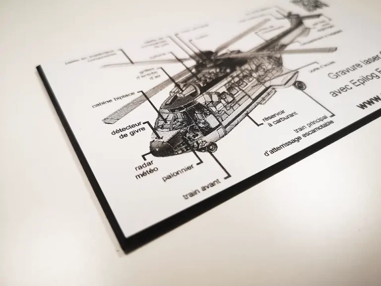 Schéma technique en noir et blanc d'un hélicoptère sur une feuille de papier, avec différentes pièces étiquetées en français - dont la biseauteuse - placées sur une surface blanche.