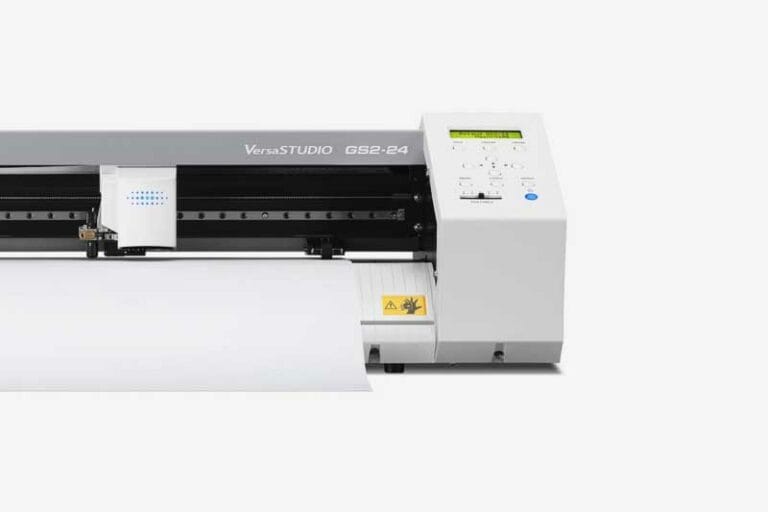 Un plotter de découpe VersaSTUDIO GS2-24 se dresse gracieusement sur un fond blanc. Son design élégant comprend un affichage numérique et des boutons de commande sur la droite, traitant avec diligence une feuille de vinyle avec précision et facilité.