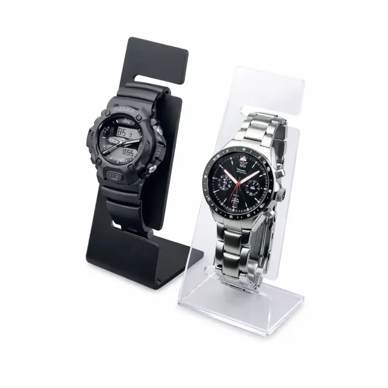 Deux montres-bracelets sont présentées sur des supports en acrylique transparent fabriqués en plieuse plastique. La montre de gauche est numérique avec un bracelet en plastique noir, tandis que celle de droite est analogique avec un cadran noir et un bracelet en métal argenté.