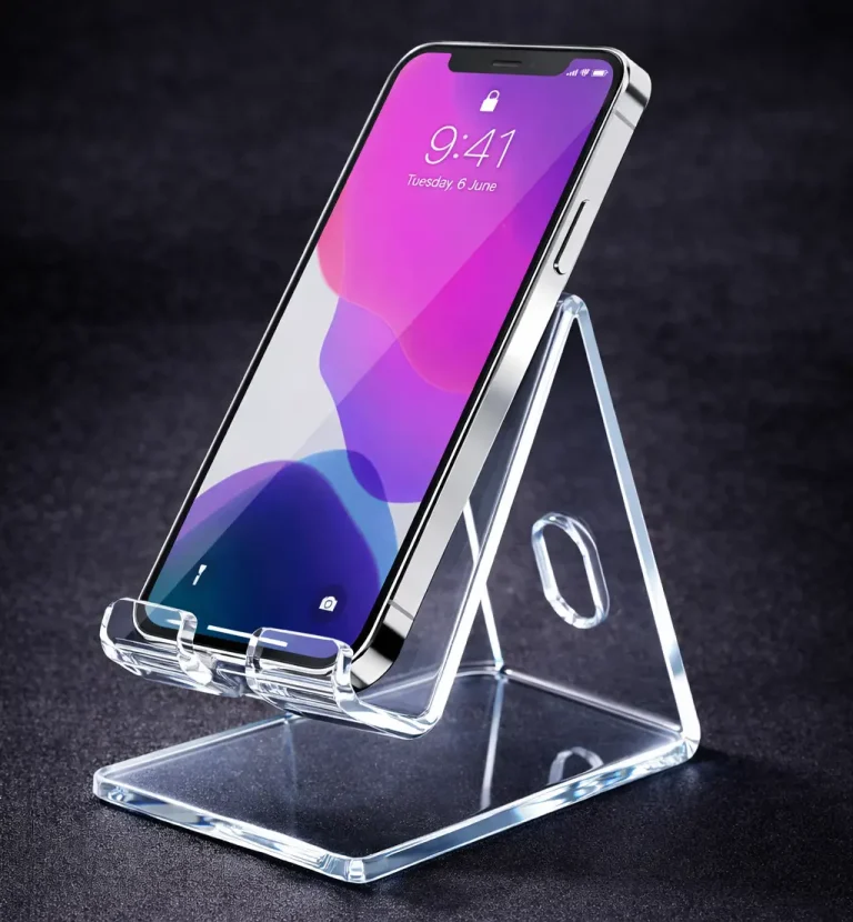 Un smartphone affichant l'heure 9:41 est placé à la verticale sur un support acrylique triangulaire transparent - fabriqué à l'aide d'une plieuse plastique - sur un fond sombre. L'écran affiche un fond d'écran dégradé violet et rose.