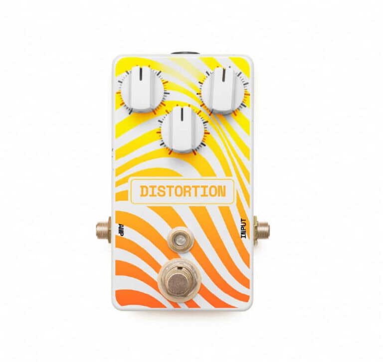 Pédale de distorsion pour guitare avec un motif tourbillonnant orange et jaune vif créé par imprimante sur objet. Elle est dotée de trois boutons blancs pour régler les paramètres sonores et de prises dentrée et de sortie clairement marquées.