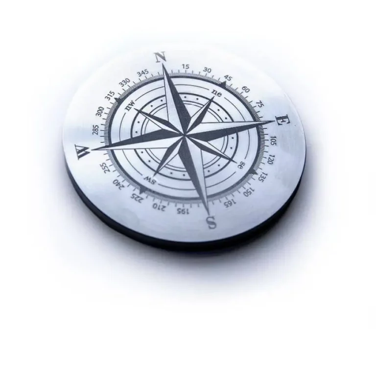 Une boussole argentée est présentée, avec une forme détoile classique et des directions marquées : N, E, S, O. Des marquages laser de précision ornent lanneau extérieur avec des notations de degrés. Sur fond blanc, elle crée un look minimaliste mettant en valeur les détails gravés au laser.