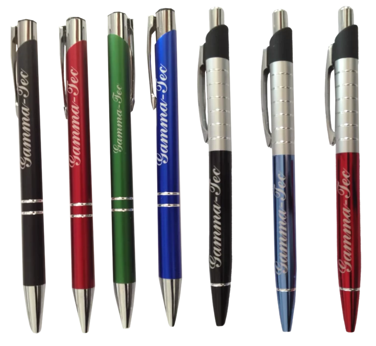 Rangée de six stylos avec embouts et clips métalliques, chacun de couleurs différentes : noir, rouge, vert, bleu, noir et marron. Conçu pour le marquage des produits, le logo Gamma-Tec est imprimé sur chaque stylo en blanc.