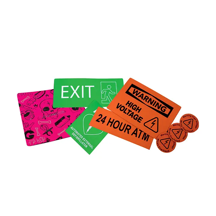 Une sélection d'étiquettes et de panneaux colorés, dont un panneau EXIT vert, des étiquettes WARNING HIGH VOLTAGE orange, des autocollants circulaires d'avertissement orange, une feuille rose avec des croquis et une étiquette de distribution électrique verte.