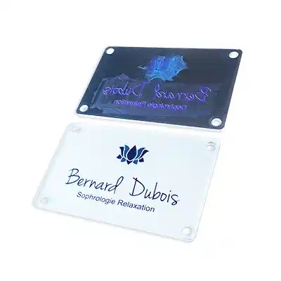 Deux panneaux rectangulaires en acrylique avec des coins arrondis et quatre trous de montage chacun. Le panneau supérieur est foncé avec un texte en couleurs claires ; le panneau inférieur est transparent avec un texte bleu indiquant Bernard Dubois Sophrologie Relaxation et un graphique de lotus.