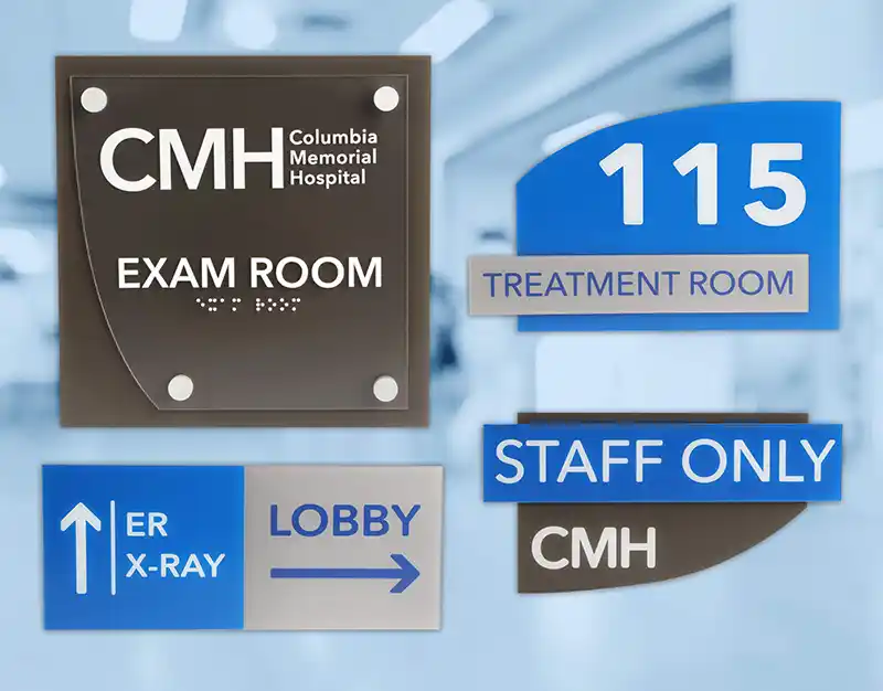 Signalétique de lhôpital Columbia Memorial, notamment « Salle dexamen », « Salle de traitement 115 », « Radiographie des urgences », « Hall » et « Réservé au personnel ». Les panneaux présentent une typographie moderne et des éléments de design dans des tons bleus et gris.