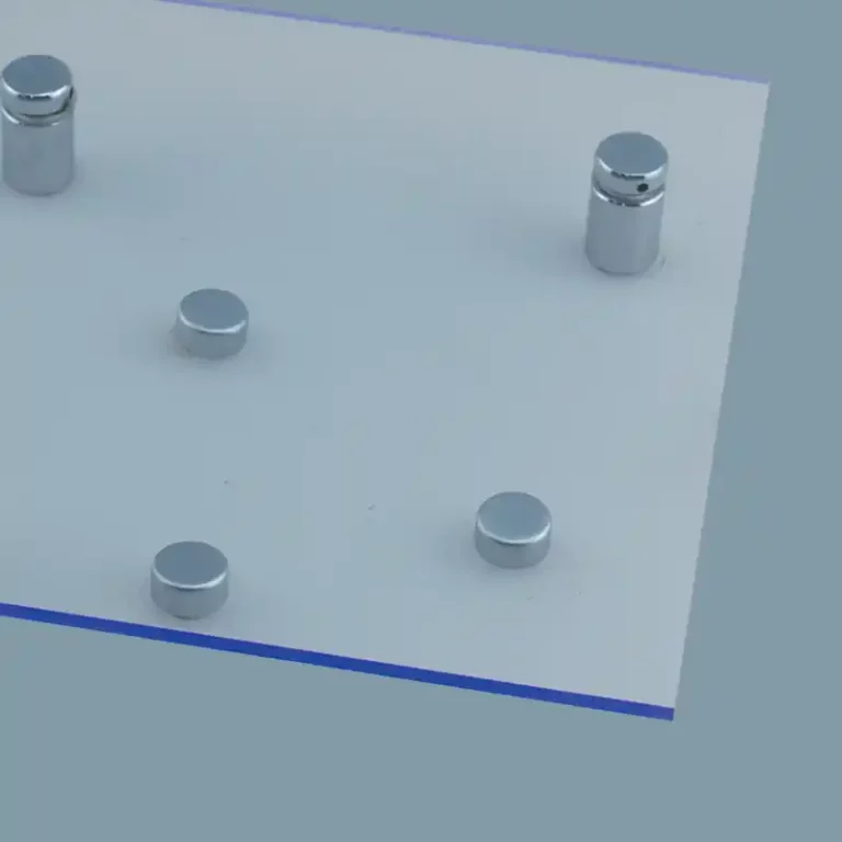 Un plateau rectangulaire gris clair avec cinq chevilles cylindriques métalliques de différentes hauteurs et tailles disposées de manière asymétrique sur sa surface. Le fond est dune couleur gris-bleu uni.