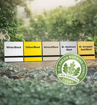 Cinq cartes rectangulaires d'échantillons de couleurs étiquetées avec des combinaisons de couleurs, y compris blanc/noir, jaune/noir, amande/noir, aluminium brut/noir et or européen brut/noir, se trouvent à l'extérieur à côté d'un badge certifié LEED.
