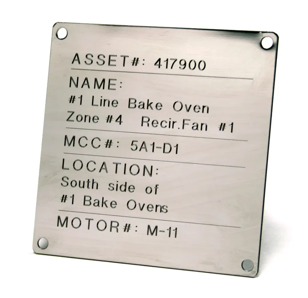 Une étiquette métallique avec un texte gravé indiquant le numéro d'actif 417900, le nom de l'équipement, le numéro MCC, l'emplacement (côté sud du four #1) et le numéro de moteur M-11.