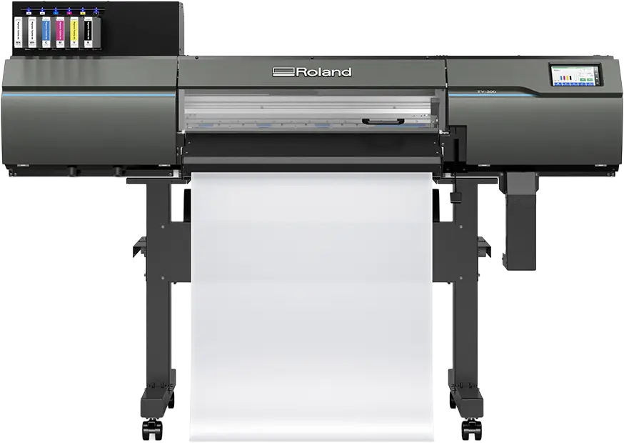 Vue de face d'une imprimante grand format Roland, avec plusieurs cartouches d'encre sur le côté gauche et un rouleau de papier chargé, prêt à imprimer des motifs DTF. L'imprimante est noire et comporte un petit écran numérique sur la droite.