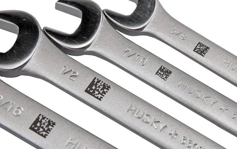 Quatre clés plates argentées de marque Husky sont montrées en gros plan, chacune marquée d'une taille différente et comportant un petit code QR noir gravé par un marqueur laser CO2 à côté de la taille sur le métal.