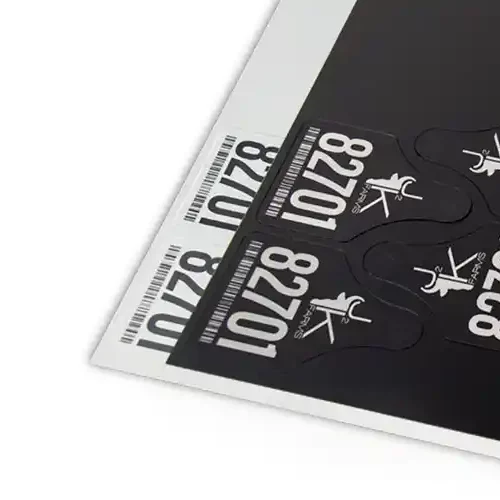 Gros plan sur des étiquettes sur fond noir. Les étiquettes comportent le numéro 82701 et une icône.