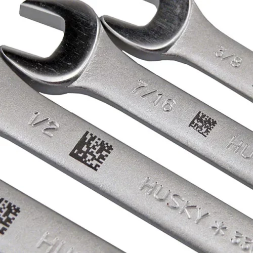 Quatre clés plates argentées de marque Husky sont montrées en gros plan, chacune marquée d'une taille différente et comportant un petit code QR noir gravé par un marqueur laser CO2 à côté de la taille sur le métal.
