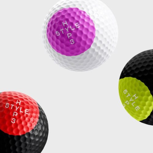 Trois balles de golf avec des sections colorées - violet, rouge et jaune-vert - marquées chacune avec H STYLE 5 P 3, forment un objet d'impression frappant sur un fond gris clair.