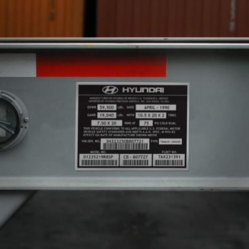 Gros plan d'une étiquette d'information sur un véhicule Hyundai affichant des spécifications telles que la date de fabrication, les limites de poids, la taille des pneus et les numéros d'identification sur une surface métallique.