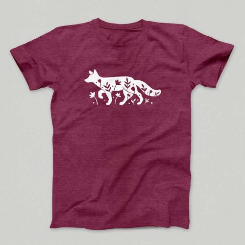 Un t-shirt bordeau présente une silhouette blanche d'un renard marchant gracieusement parmi les feuilles et les plantes, réalisée avec précision à laide dun traceur de découpe pour des détails complexes.