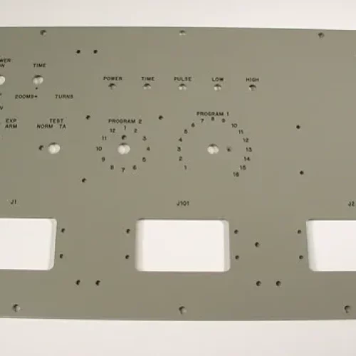 Panneau de commande rectangulaire en métal avec plusieurs trous étiquetés pour les interrupteurs et les cadrans, conçu pour les machines de fraisage héliogravure, comportant trois découpes rectangulaires en bas et diverses étiquettes telles que "POWER ON", "TURNS" et "PROGRAM 1".
