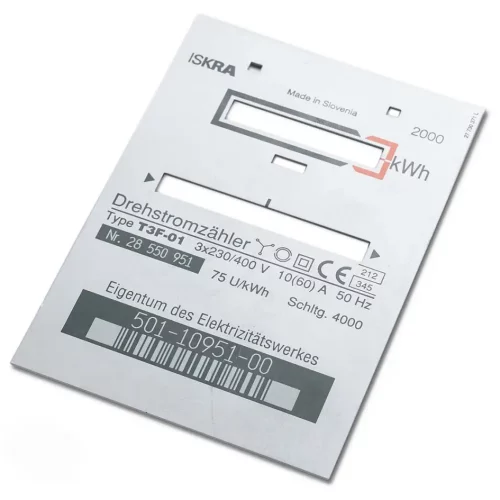 Un panneau métallique plat et rectangulaire étiqueté Drehstromzähler, comportant un code-barres, des numéros et des spécifications techniques telles que le type de modèle T3F-01, la tension et la fréquence d'un fabricant slovène - des détails gravés avec précision à l'aide d'un marqueur laser CO2.